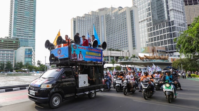 Massa dari Konfederasi Serikat Pekerja Indonesia (KSPI) melakukan pawai kemenangan satu putaran untuk paslon gubernur-wakil gubernur nomor urut 3 Pramono Anung-Rano Karno di Bundaran HI, Jakarta, Jumat (29/11/2024). [Suara.com/Alfian Winanto]