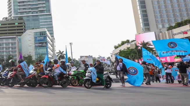 Massa dari Konfederasi Serikat Pekerja Indonesia (KSPI) melakukan pawai kemenangan satu putaran untuk paslon gubernur-wakil gubernur nomor urut 3 Pramono Anung-Rano Karno di Bundaran HI, Jakarta, Jumat (29/11/2024). [Suara.com/Alfian Winanto]