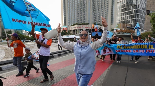 Massa dari Konfederasi Serikat Pekerja Indonesia (KSPI) melakukan pawai kemenangan satu putaran untuk paslon gubernur-wakil gubernur nomor urut 3 Pramono Anung-Rano Karno di Bundaran HI, Jakarta, Jumat (29/11/2024). [Suara.com/Alfian Winanto]