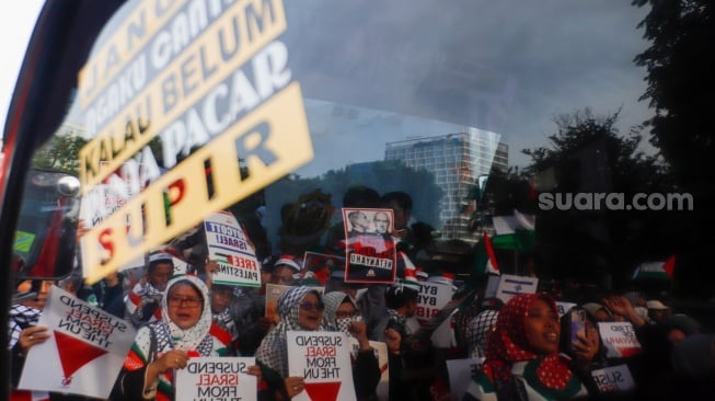 Massa berunjuk rasa saat aksi solidaritas untuk Palestina di depan Kedutaan Besar Amerika di Jakarta, Jumat (29/11/2024). [Suara.com/Alfian Winanto]