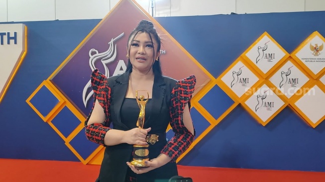 Fitri Carlina meraih Piala AMI Awards 2024 di Kuningan, Jakarta Selatan pada Rabu (4/12/2024) [Suara.com/Rena Pangesti]