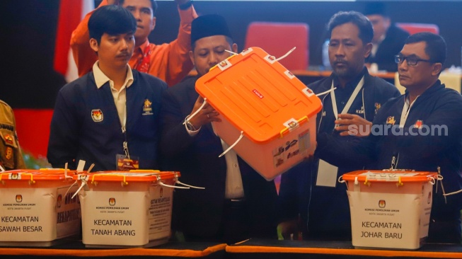 Petugas PPK Kecamatan Kemayoran membuka kotak berisi amplop form C hasil perhitungan suara disaksikan anggota KPU Kota Jakarta Pusat dan Bawaslu Kota Jakarta Pusat saat rapat pleno terbuka rekapitulasi hasil penghitungan perolehan suara dalam Pilkada serentak tahun 2024 di KotaJakarta Pusat, Rabu (4/12/2024). [Suara.com/Alfian Winanto]