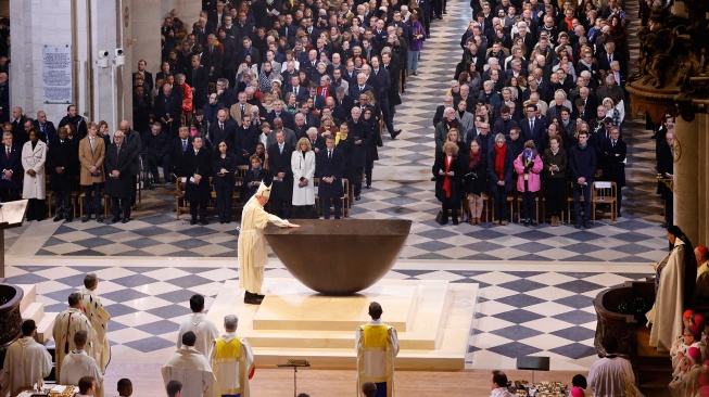 Uskup Agung Paris Laurent Ulrich (tengah-kiri) mengurapi altar utama baru selama pentahbisannya sebagai bagian dari misa pertama untuk umum, dalam upacara pembukaan kembali Katedral Notre Dame di Paris, Prancis, Minggu (8/12/2024). [Ludovic MARIN / AFP]