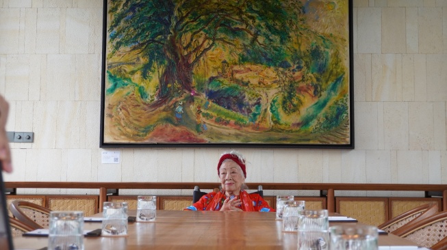 Kartika Affandi  bersama salah satu lukisannya di Garrya Bianti Yogyakarta (Dok. Garrya Bianti Yogyakarta)