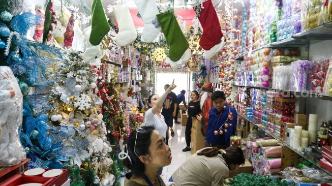 Pengunjung memilih pernak-pernik Natal yang dijual di salah satu toko di Pasar Asemka, Jakarta, Sabtu (14/12/2024). [Suara.com/Alfian Winanto]