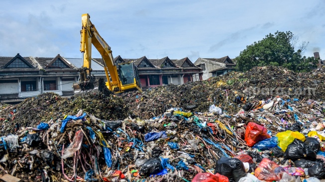 Alat berat yang dioperasikan petugas meratakan sampah yang menumpuk di Pasar Induk Caringin, Bandung, Jawa Barat, Kamis (19/12/2024). [ANTARA FOTO/Raisan Al Farisi/Spt]