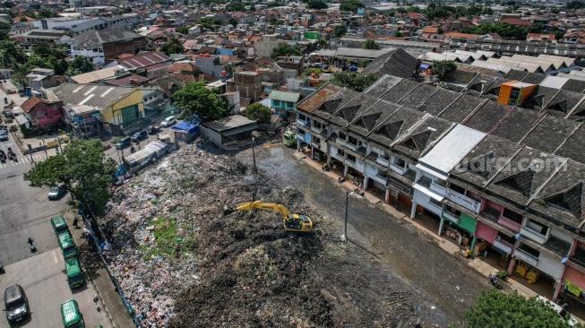 Foto udara alat berat yang dioperasikan petugas meratakan sampah yang menumpuk di Pasar Induk Caringin, Bandung, Jawa Barat, Kamis (19/12/2024). [ANTARA FOTO/Raisan Al Farisi/Spt]