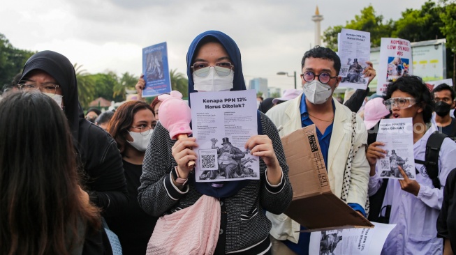 Warga melakukan aksi demontrasi menolak kenaikan PPN 12 persen di seberang Istana Negara, Jakarta, Kamis (19/12/2024). [Suara.com/Alfian Winanto]