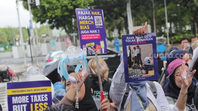 Warga melakukan aksi demontrasi menolak kenaikan PPN 12 persen di seberang Istana Negara, Jakarta, Kamis (19/12/2024). [Suara.com/Alfian Winanto]