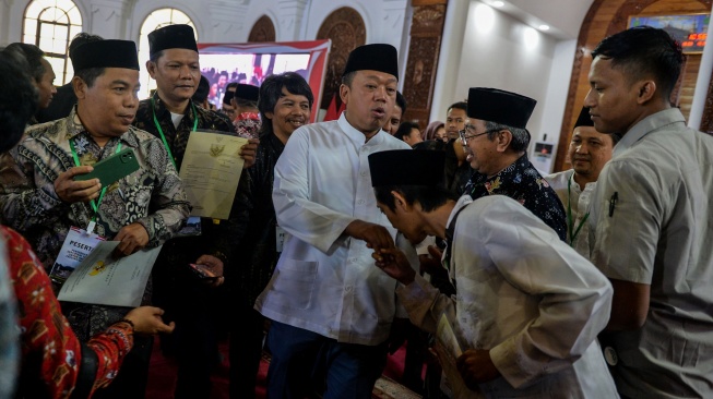 Menteri Agraria dan Tata Ruang/Kepala Badan Pertanahan Nasional (ATR/BPN) Nusron Wahid (kedua kiri) didampingi Gubernur Banten terpilih Andra Soni (kiri) dan Kepala Kantor Wilayah ATR/BPN Banten Sudaryanto (ketiga kiri) menyerahkan Sertipikat Hak Atas Tanah (SHAT) kepada warga di Masjid Raya Al-Bantani, Kota Serang, Banten, Jumat (20/12/2024). [ANTARA FOTO/Putra M. Akbar/gp/agr]