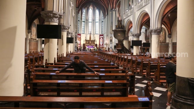 Pengurus gereja membersihkan Gereja Katedral Jakarta atau Gereja Santa Maria Diangkat Ke Surga menjelang perayaan Hari Raya Natal di Jakarta, Senin (23/12/2024). [Suara.com/Alfian Winanto]