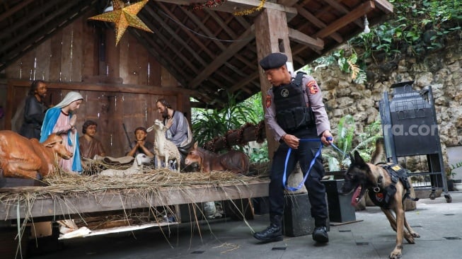 Anggota kepolisian melakukan sterilisasi di Gereja Katedral Jakarta atau Gereja Santa Maria Diangkat Ke Surga menjelang perayaan Hari Raya Natal di Jakarta, Selasa (24/12/2024). [Suara.com/Alfian Winanto]