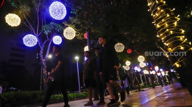 Pejalan kaki melintas di trotoar Jalan Jenderal Sudirman, Jakarta, Rabu (25/12/2024). [Suara.com/Alfian Winanto]