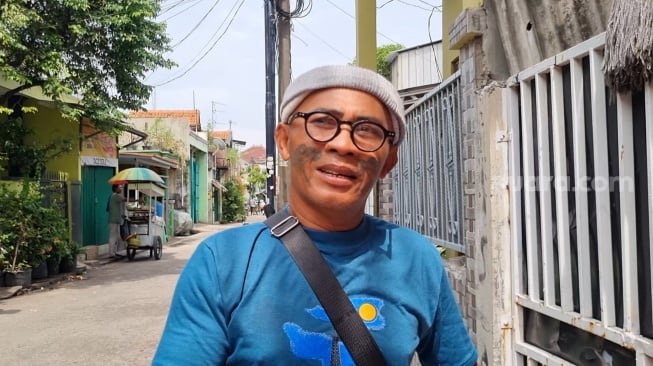 Manajer Pak Tarno, Slamet Tattoo saat ditemui Suara.com di kediaman sang pesulap di kawasan Warakas, Jakarta, Selasa (24/12/2024). [Suara.com/Adiyoga Priyambodo]