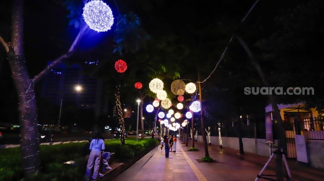 Pejalan kaki melintas di trotoar Jalan Jenderal Sudirman, Jakarta, Rabu (25/12/2024). [Suara.com/Alfian Winanto]