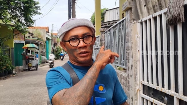 Manajer Pak Tarno, Slamet Tattoo saat ditemui Suara.com di kediaman sang pesulap di kawasan Warakas, Jakarta, Selasa (24/12/2024). [Suara.com/Adiyoga Priyambodo]