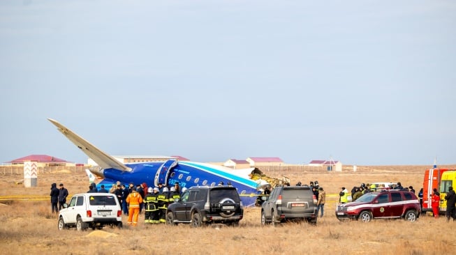 Petugas mengevakuasi puing-puing di lokasi jatuhnya pesawat penumpang Azerbaijan Airlines di dekat kota Aktau di Kazakhstan barat, Rabu (25/12/2024). [Kamilla Jumayeva / AFP]