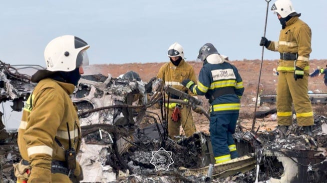 Petugas mengevakuasi puing-puing di lokasi jatuhnya pesawat penumpang Azerbaijan Airlines di dekat kota Aktau di Kazakhstan barat, Rabu (25/12/2024). [Handout / Kazakhstan's emergency situations ministry / AFP]