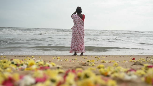 Bunga-bunga ditebar di pantai setelah para wanita melakukan ritual selama upacara yang diadakan untuk para korban tsunami Samudra Hindia 2004, di pantai Pattinapakkam di Chennai, India, Kamis (26/12/2024). [ R.Satish BABU / AFP]