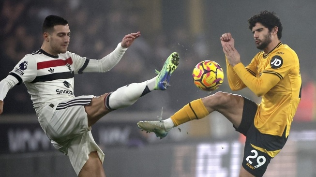 Bek Manchester United, Diogo Dalot berebut bola dengan penyerang Wolverhampton Wanderers, Goncalo Guedes selama pertandingan Liga Inggris antara Wolverhampton Wanderers vs Manchester United di stadion Molineux di Wolverhampton, Inggris tengah pada 26 Desember 2024.HENRY NICHOLLS / AFP