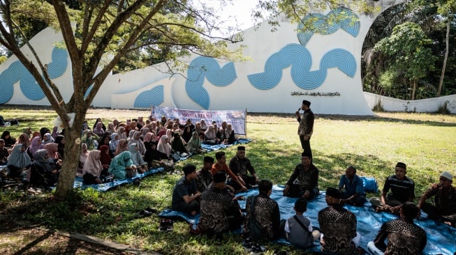 Orang-orang menghadiri doa di kuburan massal Siron, salah satu dari dua lokasi pemakaman massal utama tempat para korban tsunami Samudra Hindia 2004 di Banda Aceh, Indonesia, Kamis (26/12/2024). [Yasuyoshi CHIBA / AFP]