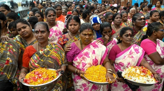 Orang-orang mengikuti prosesi untuk melakukan ritual selama upacara yang diadakan untuk para korban tsunami Samudra Hindia 2004, di pantai Pattinapakkam di Chennai, India, Kamis (26/12/2024). [ R.Satish BABU / AFP]