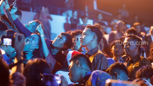 Wakil Presiden Gibran Rakabuming Raka menyapa umat nasrani saat menghadiri Perayaan Natal Nasional 2024 yang berlangsung di Indonesia Arena, Jakarta, Sabtu (28/12/2024). [Suara.com/Alfian Winanto]