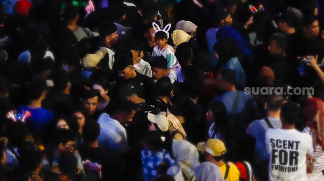 Suasana padatnya warga saat Car Free Night menyambut malam pergantian tahun di Bundaran HI, Jakarta, Selasa (31/12/2024). [Suara.com/Alfian Winanto]