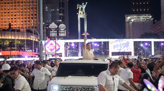 Presiden Prabowo Subianto menyapa warga dari atas mobilnya saat car free night di kawasan Bundaran HI, Jakarta, Selasa (31/12/2024). [ANTARA FOTO/Fauzan/foc]