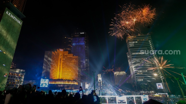 Suasana pesta kembang api saat malam perayaan tahun baru 2025 kawasan Bundaran HI, Jakarta, Rabu (1/1/2025). [Suara.com/Alfian Winanto]