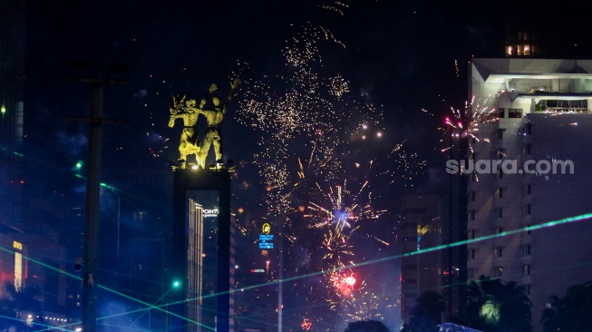 Suasana pesta kembang api saat malam perayaan tahun baru 2025 kawasan Bundaran HI, Jakarta, Rabu (1/1/2025). [Suara.com/Alfian Winanto]