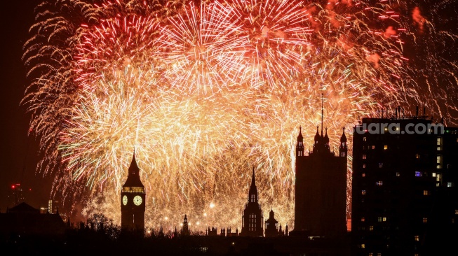 Kembang api meledak di langit di sekitar London Eye dan The Elizabeth Tower, yang dikenal dengan nama lonceng jam, "Big Ben", di Istana Westminster di pusat kota London, Inggris, Rabu (1/1/2025). [Adrian Dennis / AFP]