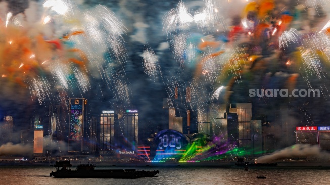 Foto ini menunjukkan kembang api di atas Pelabuhan Victoria untuk merayakan Tahun Baru di Hong Kong, Rabu (1/1/2025). [MAY JAMES / AFP]