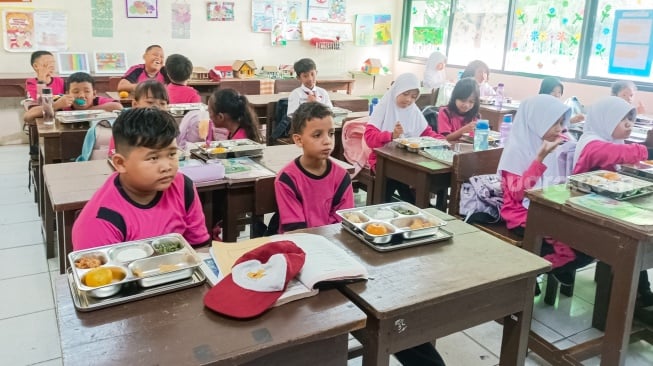 Para siswa menyantap Makanan Bergizi gratis di SDN 15 Slipi, Jakarta, Senin (6/1/2025). [Suara.com/Alfian Winanto]