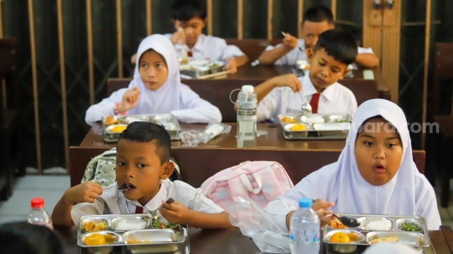 Para siswa menyantap Makanan Bergizi gratis di SDN 15 Slipi, Jakarta, Senin (6/1/2025). [Suara.com/Alfian Winanto]