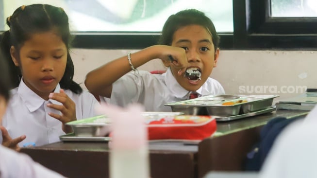 Para siswa menyantap Makanan Bergizi gratis di SDN 15 Slipi, Jakarta, Senin (6/1/2025). [Suara.com/Alfian Winanto]