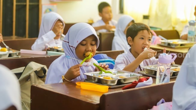 Para siswa menyantap Makanan Bergizi gratis di SDN 15 Slipi, Jakarta, Senin (6/1/2025). [Suara.com/Alfian Winanto]