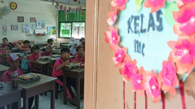 Para siswa menyantap Makanan Bergizi gratis di SDN 15 Slipi, Jakarta, Senin (6/1/2025). [Suara.com/Alfian Winanto]