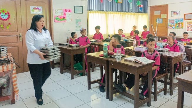 Para siswa menyantap Makanan Bergizi gratis di SDN 15 Slipi, Jakarta, Senin (6/1/2025). [Suara.com/Alfian Winanto]