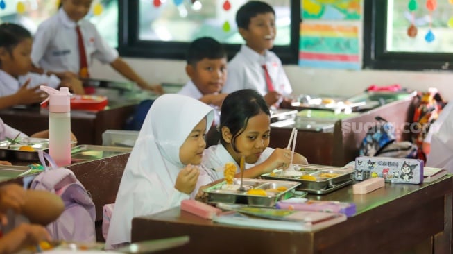 Para siswa menyantap Makanan Bergizi gratis di SDN 15 Slipi, Jakarta, Senin (6/1/2025). [Suara.com/Alfian Winanto]