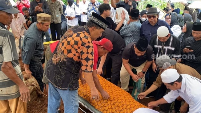 Tangis Eko Patrio dan Eman 4 Sekawan di pemakaman Nurul Qomar di TPU Carang Pulang, Kabupaten Tangerang, Kamis (9/1/2025). [Suara.com/Adiyoga Priyambodo]