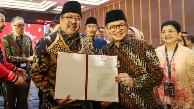 Gubernur dan Wakil Gubenur terpilih Pramono Anung dan Rano Karno menunjukan surat penetapan pada rapat pleno di Hotel Pullman Central Park, Jakarta, Kamis (9/1/2024). [Suara.com/Alfian Winanto]