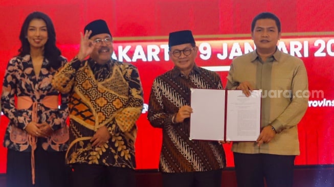 Ketua Komisi Pemilihan Umum Daerah (KPUD) Jakarta Wahyu Dinata (tengah) menyerahkan salinan putusan penetapan calon gubernur dan wakil gubernur provinsi Daerah Khusus Jakarta ke Pramono Anung-Rano Karno pada rapat pleno di Hotel Pullman Central Park, Jakarta, Kamis (9/1/2024). [Suara.com/Alfian Winanto]