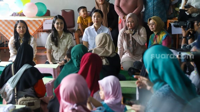 Wakil Menteri PPPA Veronika Tan (tengah) bersama Wakil Menteri BKKBN Isyana Bagoes Oka (kedua kiri) menyampaikan sosialisasi pada warga saat program Makan Bergizi Gratis (MBG) di kawasan Ciracas, Jakarta, Jumat (10/1/2025). [Suara.com/Alfian Winanto]