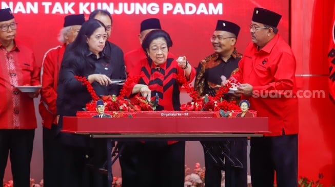 Ketua Umum PDI Perjuangan Megawati Soekarnoputri ditemani Puan Maharani memotong tumpeng saat perayaan HUT ke-52 PDIP di Sekolah Partai PDIP, Jakarta, Jumat (10/1/2025). [Suara.com/Alfian Winanto]