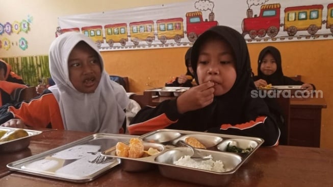 Siswa SD Negeri 1 Banyurojo, Mertoyudan menerima makan bergizi gratis. (Suara.com/ Angga Haksoro Ardi).