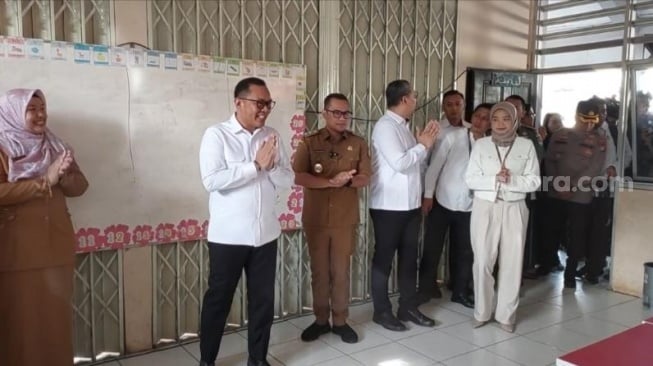 Wakil Menteri Investasi dan Hilirisasi sekaligus Wakil Kepala Badan Koordinasi Penanaman Modal (BKPM), Todotua Pasaribu saat ikut membagikan program makan bergizi gratis (MBG) di SDN Lengkong Gudang, Serpong Tangerang Selatan. (Suara.com/Moh Reynaldi Risahondua)