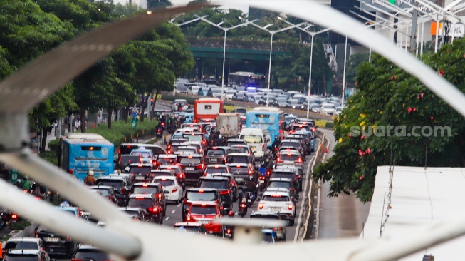 Kendaraan terjebak kemacetan di Jalan Jenderal Sudirman, Jakarta, Senin (13/1/2025). [Suara.com/Alfian Winanto]