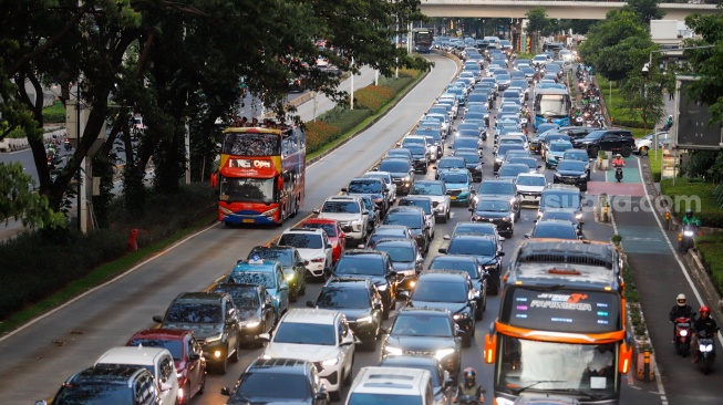 Kendaraan terjebak kemacetan di Jalan Jenderal Sudirman, Jakarta, Senin (13/1/2025). [Suara.com/Alfian Winanto]