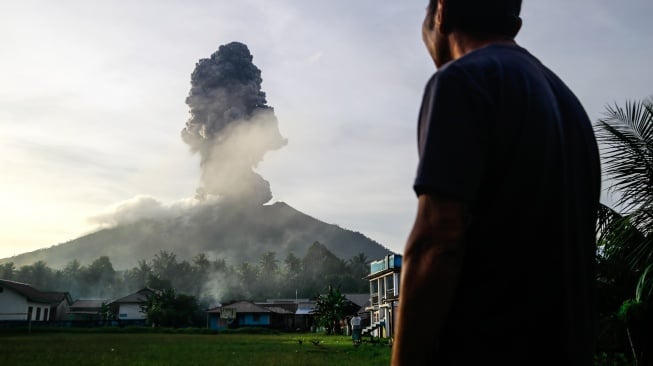 Seorang warga melihat erupsi Gunung Ibu yang tinggal di bawah kaki gunung di Desa Duono Kabupaten Halmahera Barat, Maluku Utara, Rabu(15/1/2024). [ANTARA FOTO/Andri Saputra/foc]